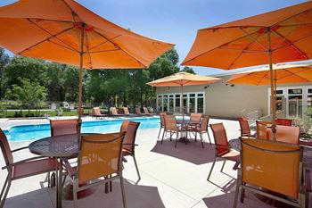 Swimming Pool Area With Shaded Chairs at Woodland Hills Apartments, Colorado